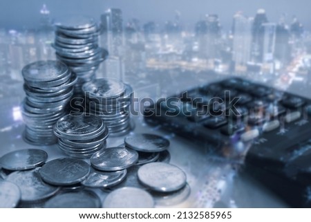 Double exposure rows of coins and calculator on night cityscape background for business and finance concept.