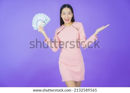 Portrait beautiful young asian woman smile with a lot of cash and money on color background
