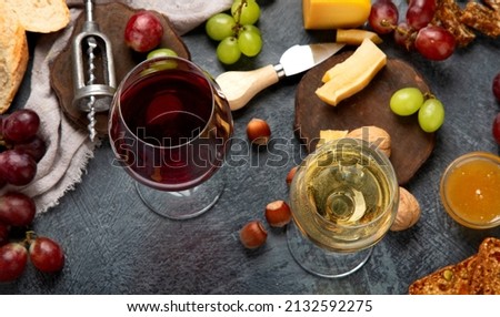 Red wine with appetizers on gray background. Summer drink for party, wine shop or wine tasting concept. Flat lay, top view