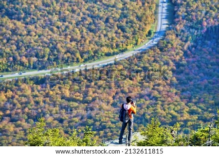 Photographer taking pictures of New England countryside, aerial view in foliage season, USA.