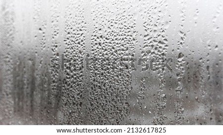 Texture condensation on the glass, outside, bad weather, rain. Steamy window with water drops made in dull day