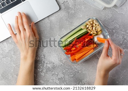 Snacking at work. Woman eating healthy snacks at work. Vegetable diet snacks. Glass container Royalty-Free Stock Photo #2132618829