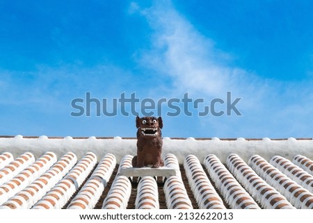 Shisa symbol of Okinawa Lion on original Ryukyu architecture roof art Okinawa island Japan Royalty-Free Stock Photo #2132622013