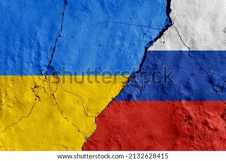 Russia and Ukraine painted flags on a wall with a crack. War, conflict between Ukraine and Russia Royalty-Free Stock Photo #2132628415
