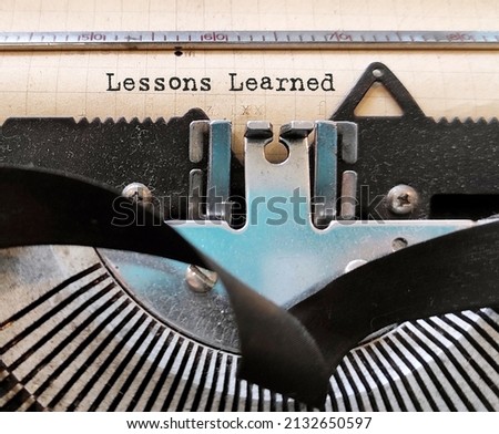 Old dirty vintage typewriter with text typed LESSONS LEARNED, means  knowledge or understanding, positive or negative, gained by past experiences whicj can be advantages to future activities Royalty-Free Stock Photo #2132650597