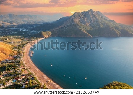 Long beach coast, dark teal sea and bay in Adrasan village Mediterranean coast, great place for holiday. background mountains, forest and sunrise sky. Aerial view with drone. Antalya, TURKEY Royalty-Free Stock Photo #2132653749