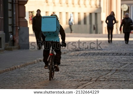 Courier On Bicycle Delivering Food In City Royalty-Free Stock Photo #2132664229