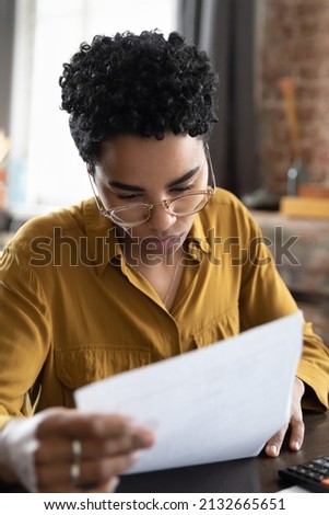 Focused concerned African employee woman holding document with bad problem news. Frustrated student girl receiving paper letter, rejection notice from university, feeling puzzled, upset Royalty-Free Stock Photo #2132665651