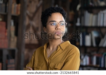 Serious young African business woman in casual glasses head shot portrait. Thoughtful Black businesswoman looking away with pensive face, dreaming, thinking over project tasks, problem solving Royalty-Free Stock Photo #2132665841