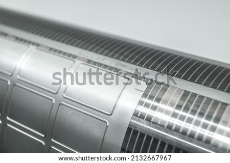 Used magnetic cylinder with attached flexible die for die cutting on rotary printing press. Die-cutting of labels. Cut knife for paper labels. Rotary stamp. Offset cutting knife for printing machine Royalty-Free Stock Photo #2132667967