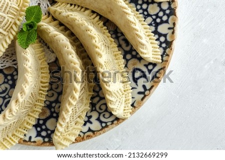 Homemade sweets from gazelle horns for Ramadan. Close-up detail shot of fresh baked Kaab El Ghazal, a moroccan sweet also known as gazelle horns, Halal food Royalty-Free Stock Photo #2132669299