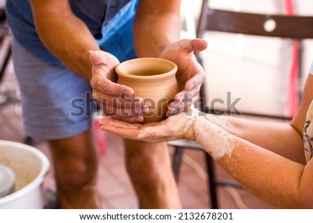 close-up of the Potter's hands holding a clay pot he made