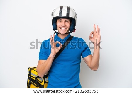 Young caucasian man with thermal backpack isolated on white background showing an ok sign with fingers