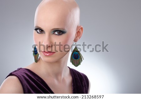 Studio portrait of bald woman wearing elegant claret velvet dress.