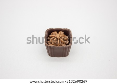 One chocolate candy with filling on white background