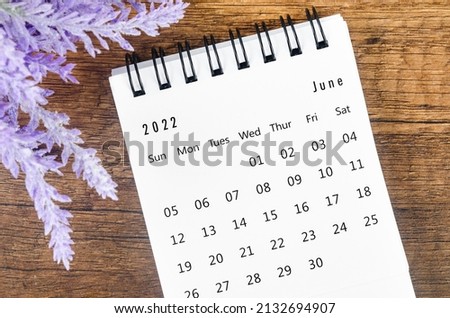 The June 2022 desk calendar with flower on wooden background. Royalty-Free Stock Photo #2132694907