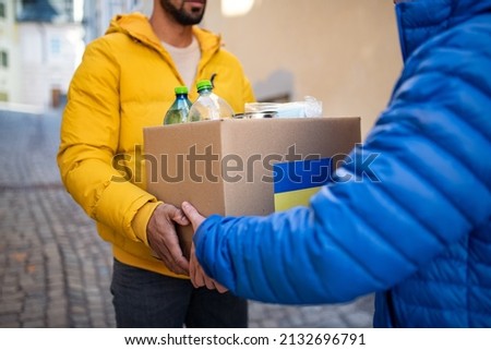 Cropped shot of volunteers collecting boxes with Humanitarian aid for Ukrainian refugees in street Royalty-Free Stock Photo #2132696791