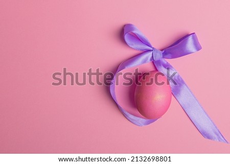 easter red egg and lilac bow on pink background