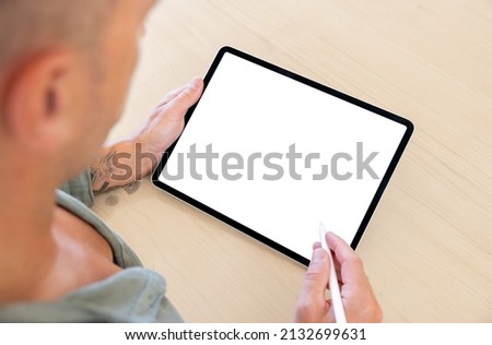 Person using stylus pen with tablet computer, blank white screen mockup