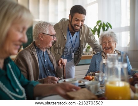 Group of cheerful seniors enjoying breakfast in nursing home care center. Royalty-Free Stock Photo #2132703569