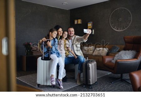 Happy young family with two children taking selfie at luxury hotel, summer holiday. Royalty-Free Stock Photo #2132703651