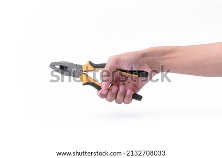 The hand of a man is holding a black yellow pliers isolated on the white background