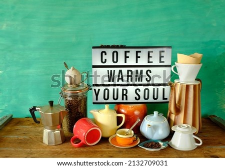 Vintage coffee pots, cups and coffee makers with illuminated sign and slogan coffee warms your soul. Cafe, restaurant or coffee advertising concept, free copy space.