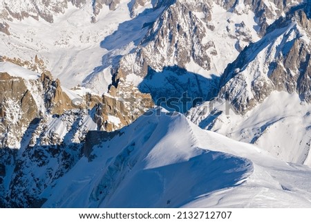 This landscape photo was taken in Europe, in France, Rhone Alpes, in Savoie, in the Alps, in winter. We see the snow-capped mountains of the Mont Blanc massif, under the Sun.