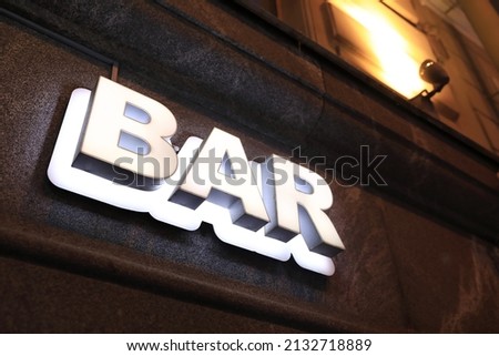 View of luminous bar signboard on wall of building at night Royalty-Free Stock Photo #2132718889