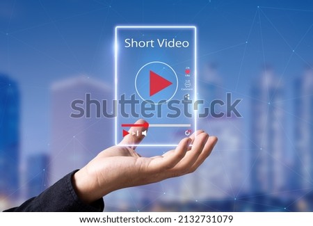 Short Video marketing concept.Man hands holding virtual short video player with blurred city as background Royalty-Free Stock Photo #2132731079