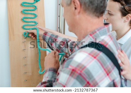 Man in occupational therapy with therapist training his dexterity Royalty-Free Stock Photo #2132787367