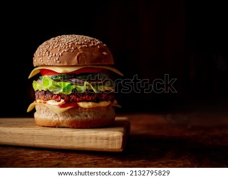 Hamburger with sesame seeds bun. Wooden background. Food concept. Hamburger day.
