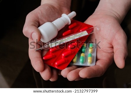 Colored Pills, Tablets and Capsules Blisters for Pharmacy and Medicine Holding in Hand. Healthy and medicine concept. Blue Background. High quality photo