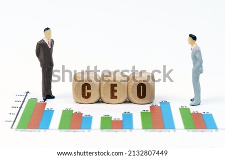 Business and finance concept. On financial reports with graphs, a figure of businessmen and wooden cubes with the inscription - CEO