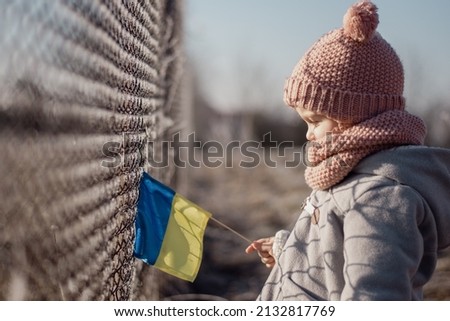 Girl holding Ukrainian flag, asking for peace, children against war, kids in danger, freedom, stop fighting, Blue Yellow Royalty-Free Stock Photo #2132817769