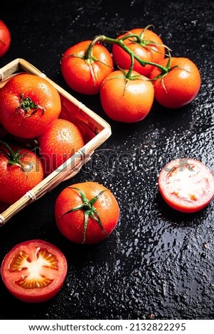 Ripe tomatoes in a basket. On a black background. High quality photo