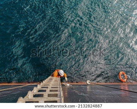 A ship crew is painting draft mark or load line of a cargo ship or bulk carrier Royalty-Free Stock Photo #2132824887