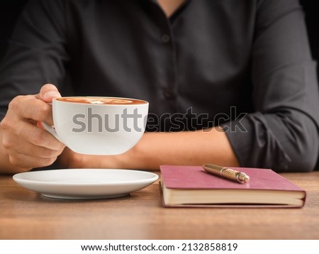 Businessman hand holding a cup of coffee sitting working at the office. Close-up photo. Beverage and relaxation concept 