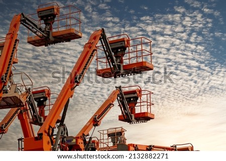 Articulated boom lift. Aerial platform lift. Telescopic boom lift against blue sky. Mobile construction crane for rent and sale. Maintenance and repair hydraulic boom lift service. Crane dealership.  Royalty-Free Stock Photo #2132882271