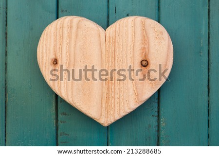Love Valentines wooden heart from recycled old palette on turquoise painted background, copy space