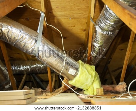 View of fiber glass duct for central air in an attic. Royalty-Free Stock Photo #2132888851