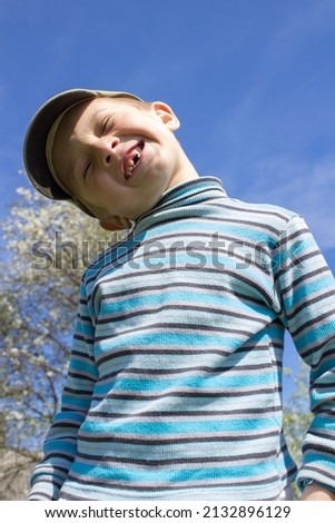Smiling boy without front teeth, outdoors in the spring