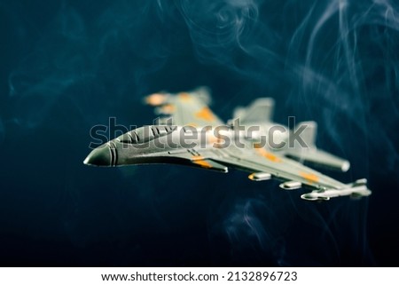 Jet fighter airplane silhouette on blue background with smoke
