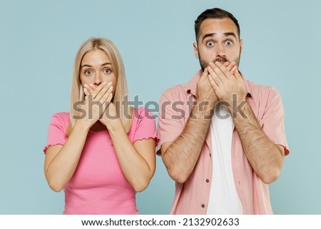 Young couple two friends family man woman in casual clothes looking camera cover mouth with hand together isolated on pastel plain light blue color background studio portrait People lifestyle concept Royalty-Free Stock Photo #2132902633