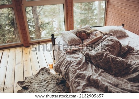 The girl is sleeping on the bed. A young and beautiful girl sleeps with a beautiful view from the window. High quality photo