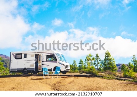 Beautiful tourism camper van campsite in the nature. Travel and rv renting vehicle vacation. Vanlife and wanderlust concept with modern motorhome parked in the nature with blue sky background Royalty-Free Stock Photo #2132910707