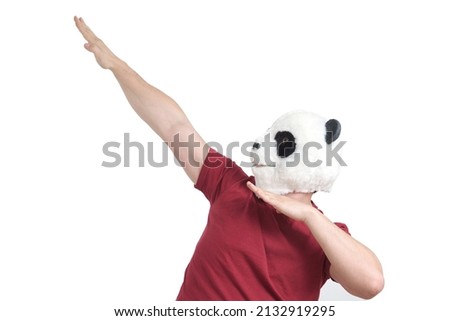 Man wearing a panda mask head showing dab move, isolated on white background in studio.