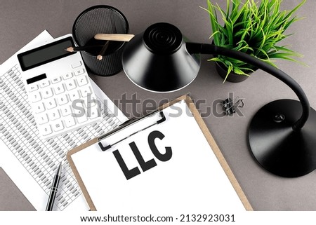 Clipboard ,chart and calculator, lamp and workspace accessories on a grey table. Top view , LLC