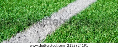 Part of football or soccer field close up, Artifical green grass with white border lines, Astroturf at stadium for spart games Royalty-Free Stock Photo #2132924191