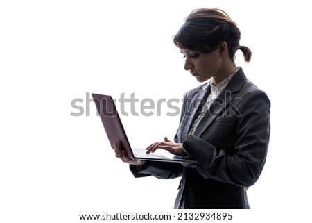Silhouette of Caucasian woman using laptop PC.